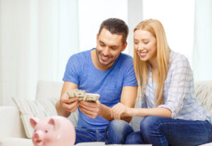 smiling couple counting money at home