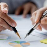 Right Mutual Fund - Two People Pointing Pen on The Pie Chart