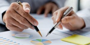 Right Mutual Fund - Two People Pointing Pen on The Pie Chart