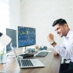 Trader in happy mode with Laptop with tarding graph (1)